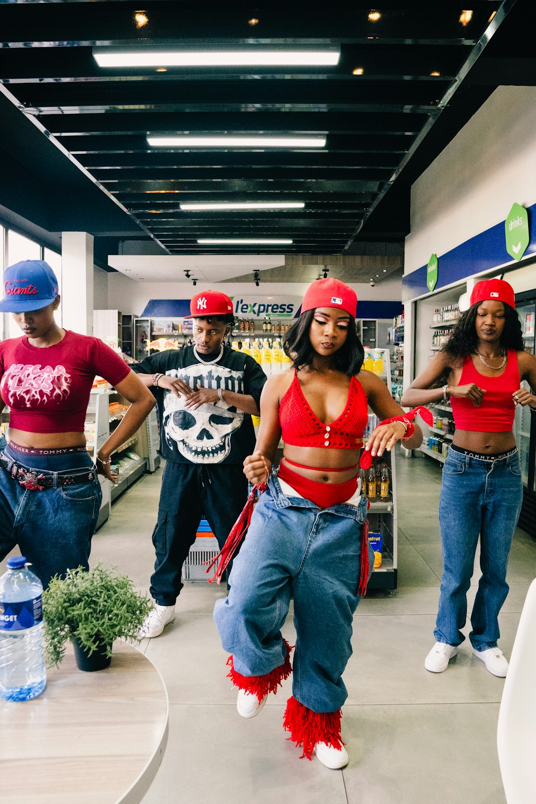 Four dancers moving together in matching red